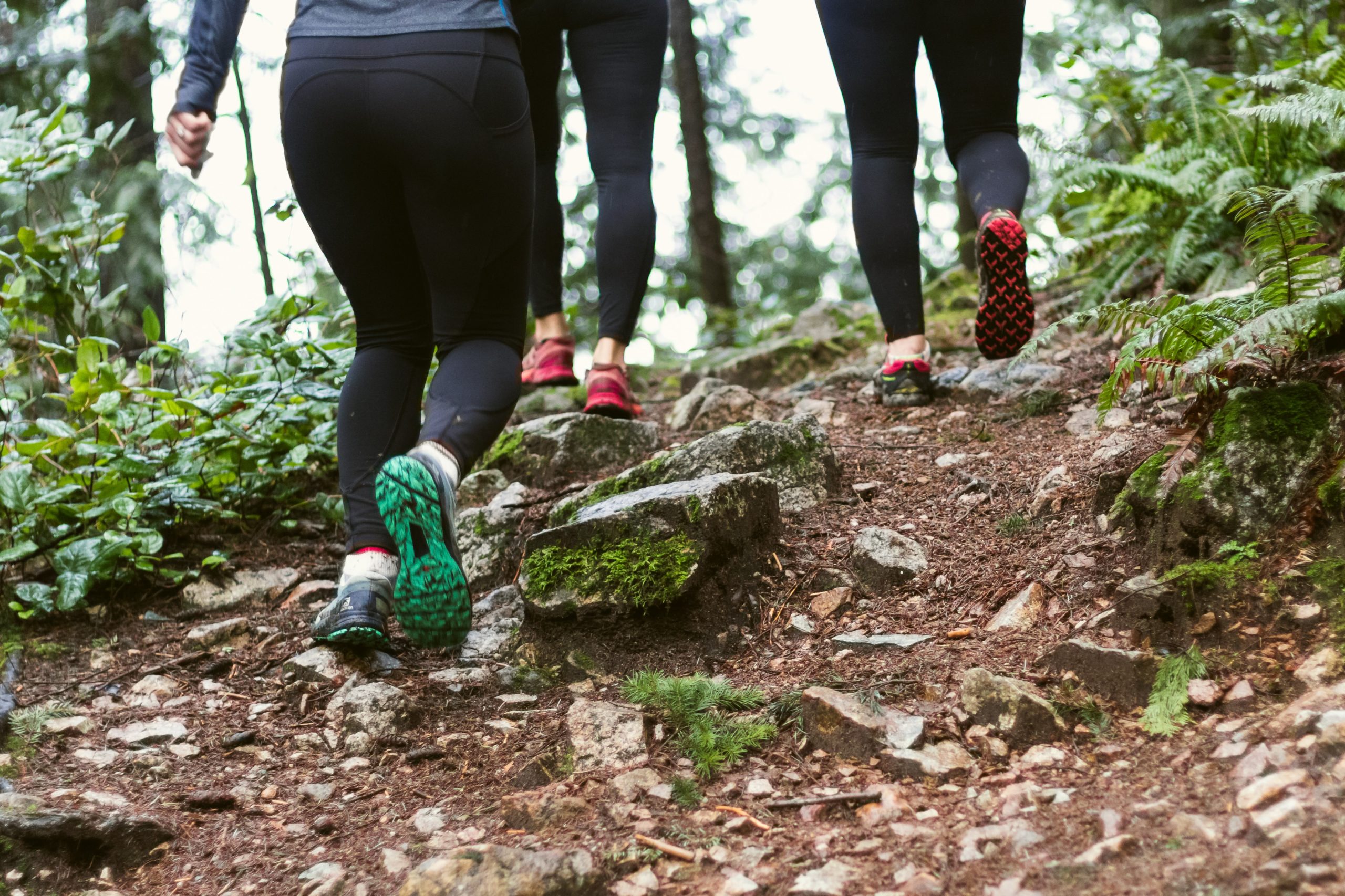 three women running on mountain trail